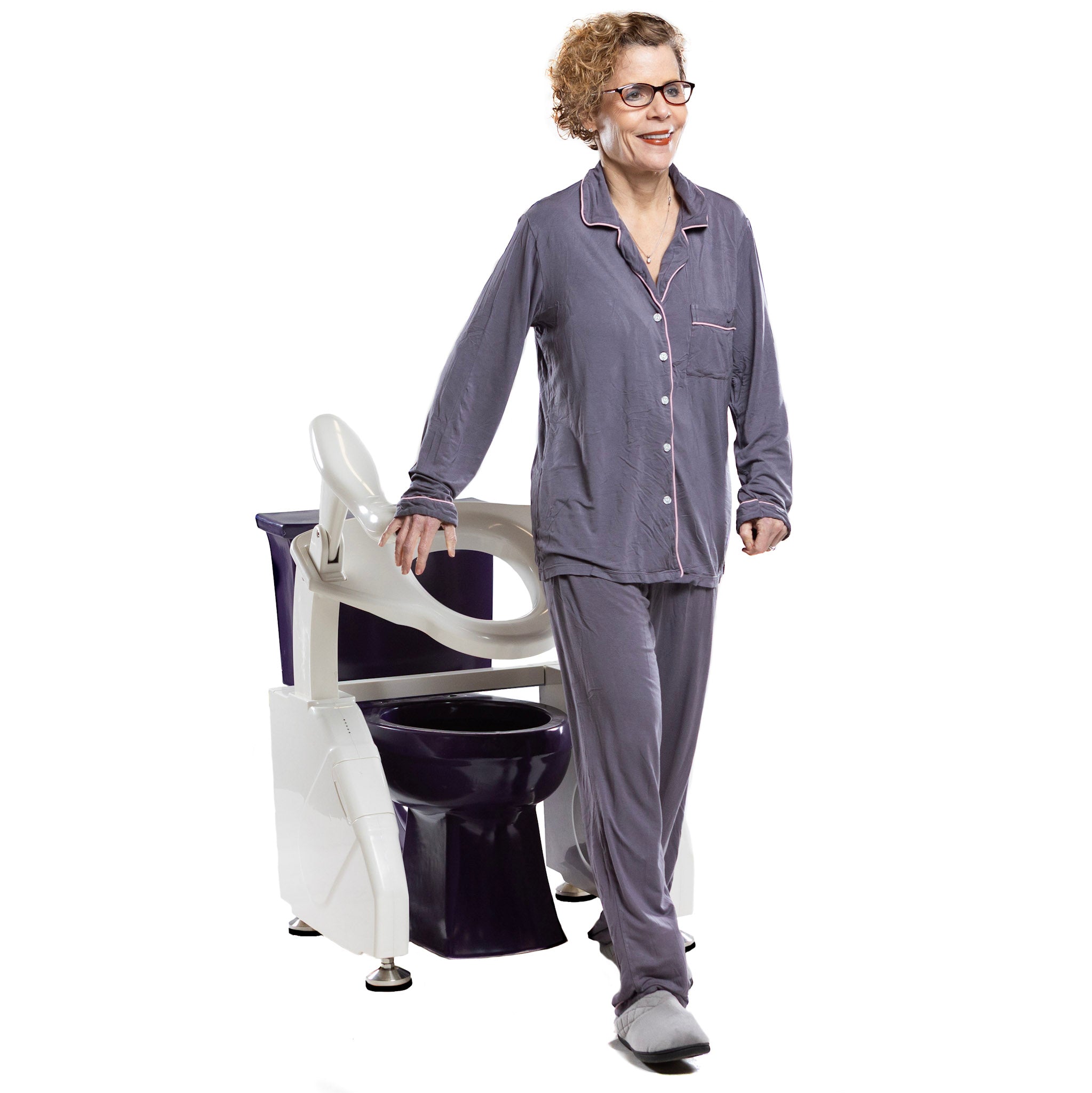 Dignity Lifts Deluxe Toilet Lift DL2 - A woman wearing gray pajamas stands next to a white and dark purple toilet lift chair on a solid white background.