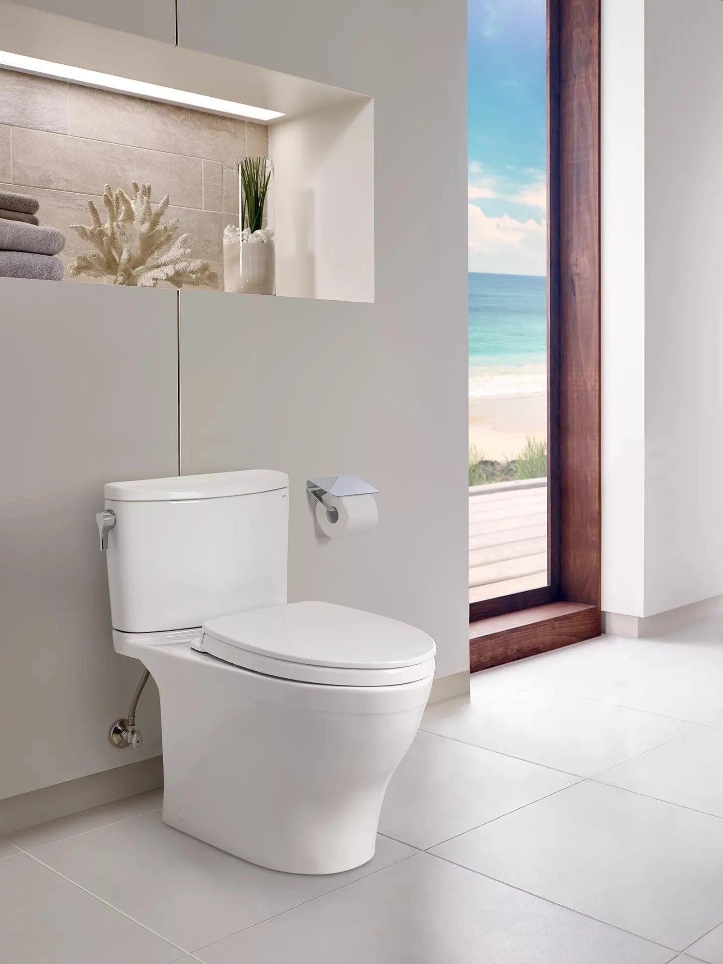 Modern bathroom with TOTO Nexus two-piece toilet and beach view window.