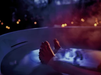 TOTO Flotation Tub With ZERO DIMENSION - Person's foot in a bathtub with steam and blurred lights in the background