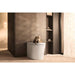 Duravit SensoWash Starck I Plus - A modern white toilet with a brown tabby cat sitting on the lid, set in a minimalist bathroom with warm beige walls and dark wood cabinetry.