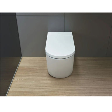 Duravit SensoWash Starck I Pro - A white  toilet with a closed lid sits on a light wood floor against a dark gray wall.