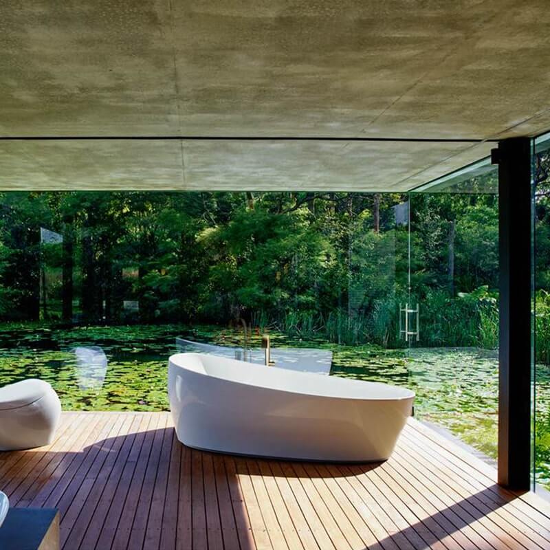 TOTO Flotation Tub with Zero Dimension overlooking serene pond, on elegant wooden deck, surrounded by lush greenery.