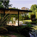 Modern outdoor deck featuring TOTO Flotation Tub with Zero Dimension, surrounded by lush greenery and scenic pond.