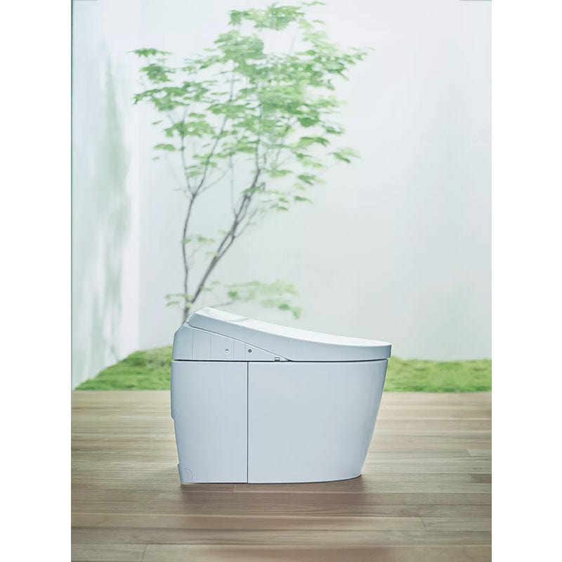 TOTO Neorest AH Dual Flush Integrated Bidet Toilet with modern design against a serene backdrop of green foliage and wood flooring.