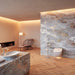 TOTO NEOREST® WX2 Wall-Hung Toilet - Modern bathroom with stone walls, wooden floor, and minimal decor.