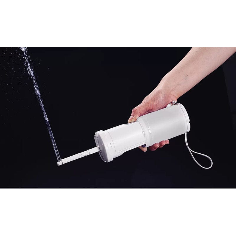 Portable TOTO Travel Washlet in hand, showing water spray feature for hygiene on-the-go.